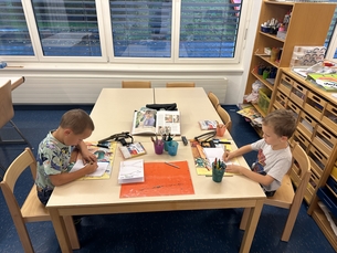 Dario und Nelio aus dem grossen Kindergarten gingen mit Begeisterung an ihr neuestes Projekt heran: Der Bau einer eigenen Steinschleuder! Ihre Motivation und ihr Erfindergeist waren von Anfang an sprbar. Mit funkelnden Augen starteten sie die Suche nach einer passenden Astgabel  dem Herzstck jeder Schleuder. Nach einigem Erkunden des Frauenwaldes fanden sie schliesslich den perfekten Ast. Unter genauer Anleitung von Herrn Riederer kam zum ersten Mal die Sge des Taschenmessers zum Einsatz und die Jungs sgten mit Feuerseifer den zuvor entdeckten Ast damit ab.  Besonders spannend fr die Kinder war der vertiefte Umgang mit dem Taschenmesser. Unter sorgfltiger Anleitung schnitten sie die Astgabel zu und versahen diese mit den ntigen Kerben fr die Gummischlinge. Dabei zeigten sie grosse Geduld und beharrliche Ausdauer. Auch wenn nicht jeder Handgriff auf Anhieb sass, waren Nelio und Dario sichtlich stolz auf ihr Werk. Parallel dazu erstellten sie ein Rapportheft, in dem sie ihre Schritte zeichnerisch festhielten, um den Arbeitsprozess genau zu dokumentieren  richtig wie kleine Konstrukteure!  Dann kam der Moment, auf den sich die beiden Buben besonders freuten: Der erste Test ihrer Steinschleuder! Doch bevor es losging, lernten die beiden die wichtigen Regeln fr den verantwortungsvollen Umgang mit ihrem neuen Spielzeug. Mit grosser Aufmerksamkeit hrten sie zu, als erklrt wurde, dass die Schleuder nie auf Menschen oder Tiere gerichtet werden darf.  Nach ein paar Optimierungen hielten die Beiden am Ende eine gelungene Steinschleuder in den Hnden, die nicht nur ein funktionales Werkzeug war, sondern auch ein Zeichen fr ihre Ausdauer, Lernbereitschaft und Kreativitt. Ihre Augen funkelten noch strker und die Freude und der Stolz, etwas Eigenes erschaffen zu haben, war in ihre Gesichter geschrieben. 